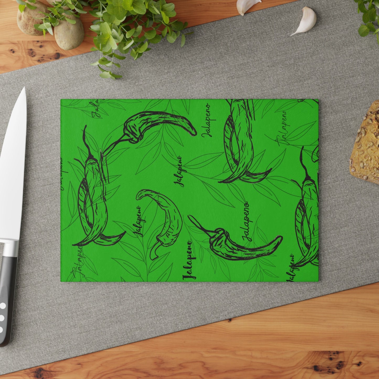 Glass Cutting Board with Original Jalapeno Hand Drawings Over Green Background